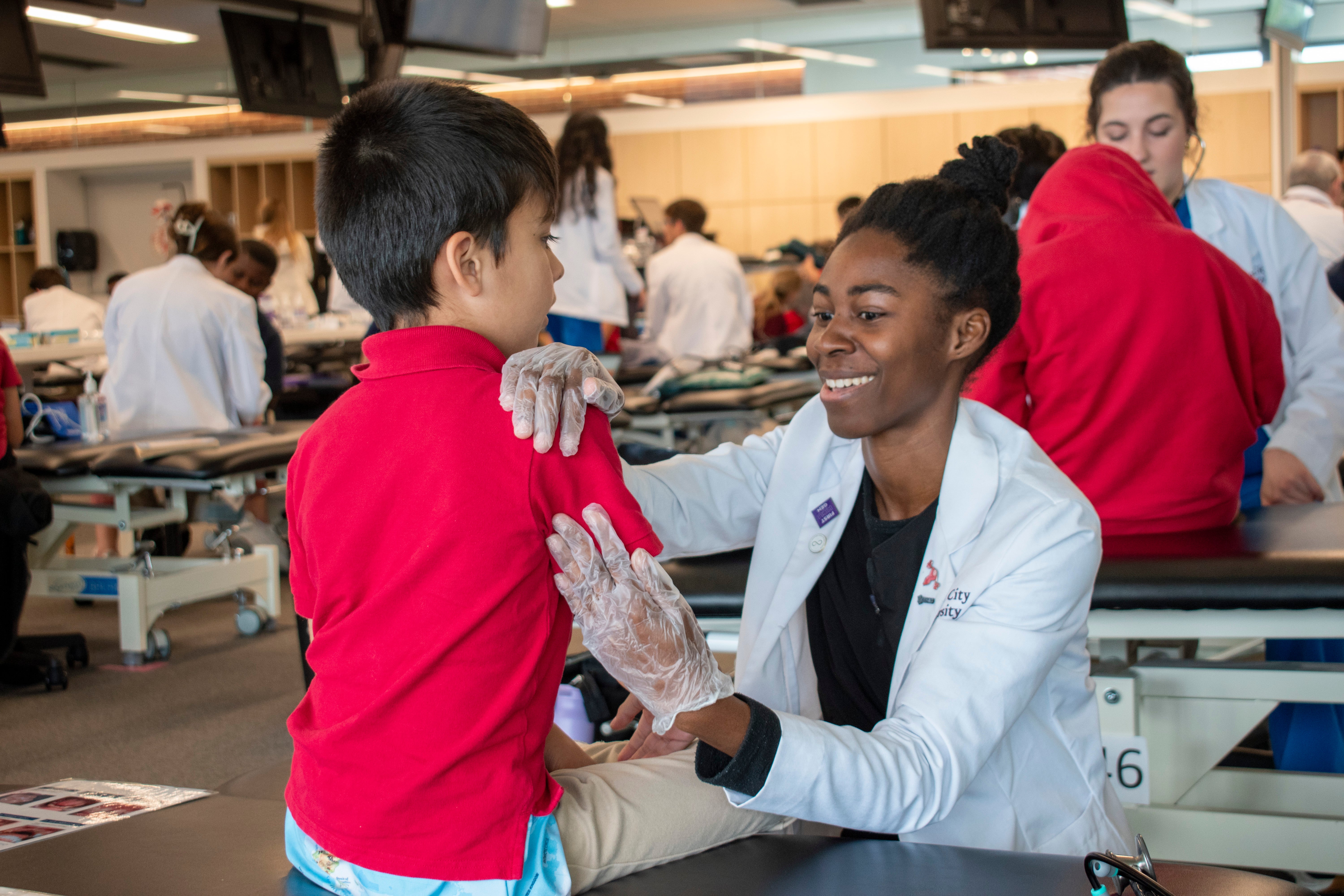Alt text: image of student doctor performing an exam on a young boy